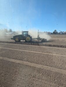 A tractor and laser leveling to prepare for planting alfalfa